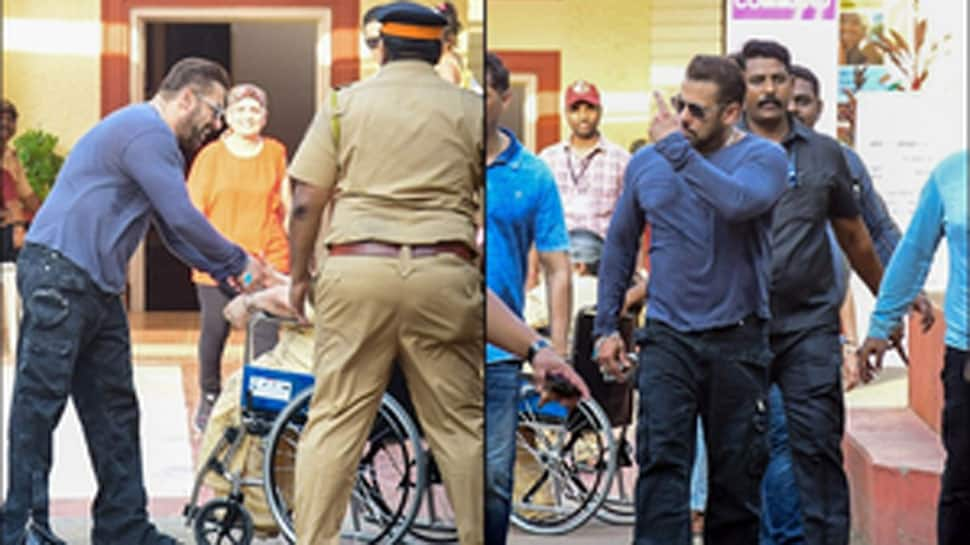 Salman Khan talks to a woman sitting in a wheelchair before casting her vote